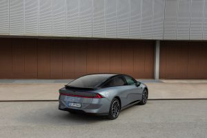 XPENG P7+, schräg von hinten vor einer Gebäudefassade